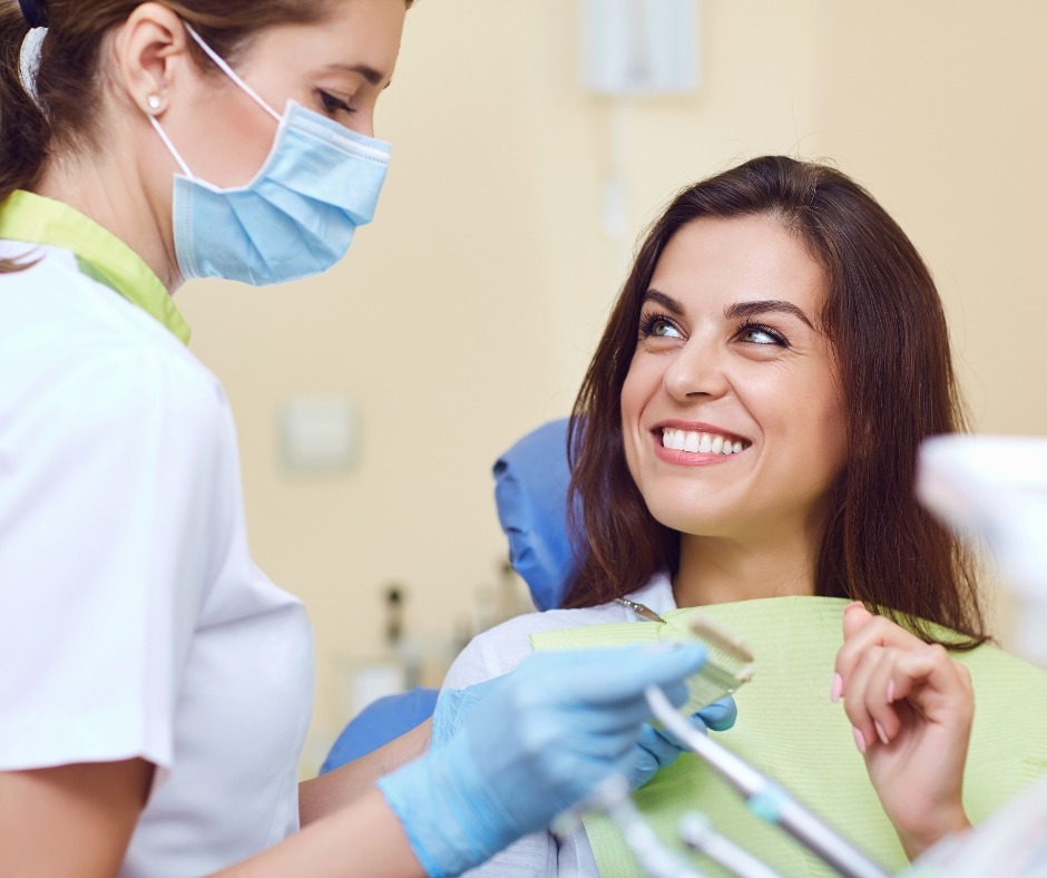 Smiling woman in the dental chair beside her dentist